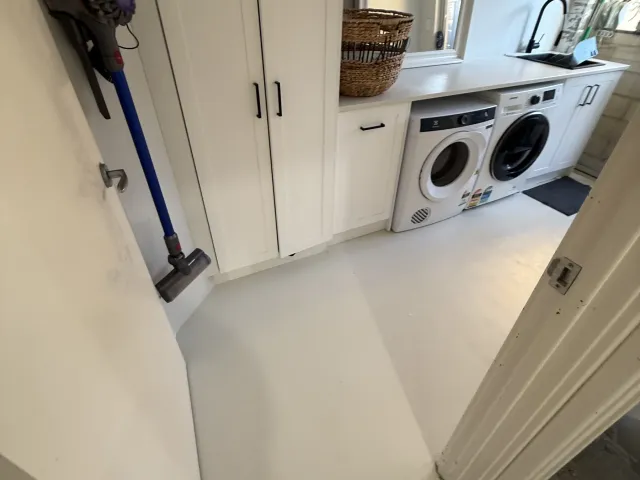 Laundry renovation with custom cabinetry, washer and dryer, and a sink